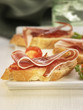 spanish ham and tomato on a bite-size slice of bread
