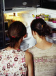 girls looking in a refrigerator