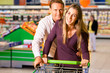 Paar im Supermarkt mit Einkaufswagen
