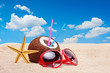 A coconut, starfish and a sunglasses on a beach