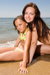 Young mother and little daughter sitting at sea