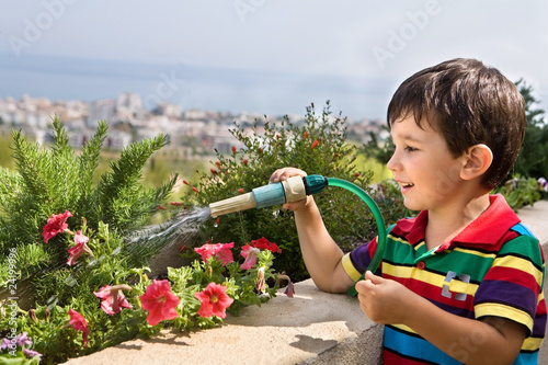 Photo: boy watering flowers boy watering flowers