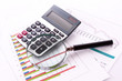 calculator and magnifier on chart background