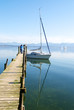 Sailing boat and reflection in Chiemsee lake pier, Germany