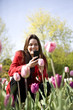 A young woman photographing flowers with her phone