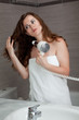 dressed in towel beautiful woman using fen at modern bathroom