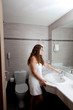 dressed in towel beautiful woman staying at modern bathroom