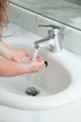woman washing hands at modern marble bathroom. bubbled water