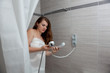 gorgeous woman behind curtain making a call at modern bathroom