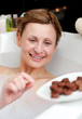 Bright woman eating chocolate while having a bath Bright woman eating chocolate while having a bath