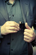 man taking a flask out of his suit pocket man taking a flask out of his suit pocket