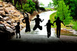 Young Children Playing and Jumping in Sillouette in Rain