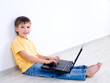 Child with laptop in empty room