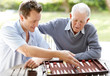 Father and son playing backgammon in a park