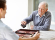 Elderly person playing backgammon with a young guy