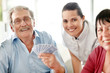 Mature woman with old people playing cardgame
