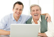 Portrait of excited father and son sitting together with a lapto