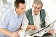 Father and son reading newspaper together