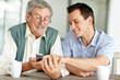 Young son teaching his father to operate a cellphone