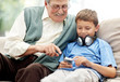Old man sitting with his grandson listening to music