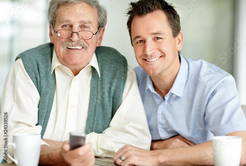 Foto: Portrait of happy father and son sitting together Portrait of happy father and son sitting together