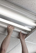 man installs fluorescent lamp in ceiling ballast man installs fluorescent lamp in ceiling ballast