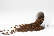 kaffeebohnen fallen aus umgekippter tasse