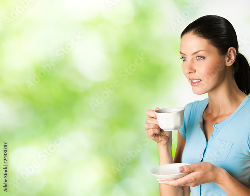 Foto: Young happy smiling woman drinking coffee, outdoors Young happy smiling woman drinking coffee, outdoors