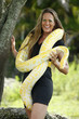 Young woman plays with an albino burmese python