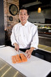 Foto: Japanese chef slicing raw fish for sushi Japanese chef slicing raw fish for sushi