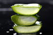 slice green leaf of aloe on black