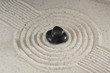 Schwarze Steine Hot Stones im Sand mit Spuren Schwarze Steine Hot Stones im Sand mit Spuren