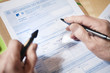 close-up of a man's hands filling a form
