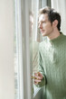 man looking out through a door glass