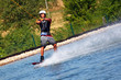 Junger Mann Wakeboarder rast über das Wasser