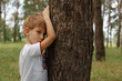 little boy in pines forest