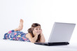 Junges Mädchen mit Laptop schaut im liegen