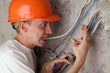 Worker electrician teeth compresses dangling wires