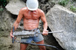kräftiger Bauarbeiter mit Helm und Schremmhammer