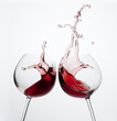 Two wine glasses in toasting gesture with big splashing