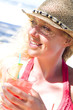 Junge Frau mit Cocktail am Strand