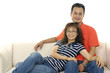 Asian couple sitting on sofa embracing