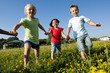 Three children running holding hands
