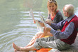 Großvater und Enkelin beim Zeitunglesen im Grünen am Teich