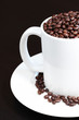 Coffee mug and saucer filled with fresh coffee beans Coffee mug and saucer filled with fresh coffee beans