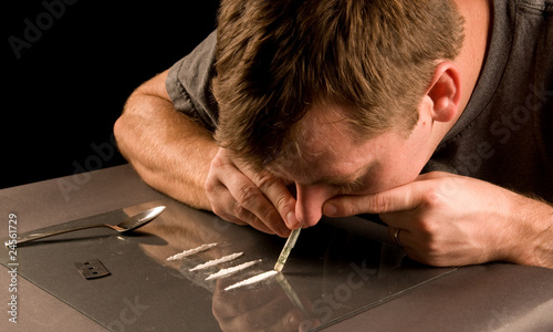 Photo: young man snorting lines of cocaine young man snorting lines of cocaine