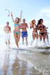 happy teenagers playing at the sea