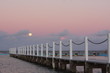 Full moon rising over the ocean at sunset
