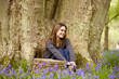 A young woman sitting under a tree, relaxing