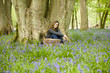 A young woman sitting under a tree, relaxing